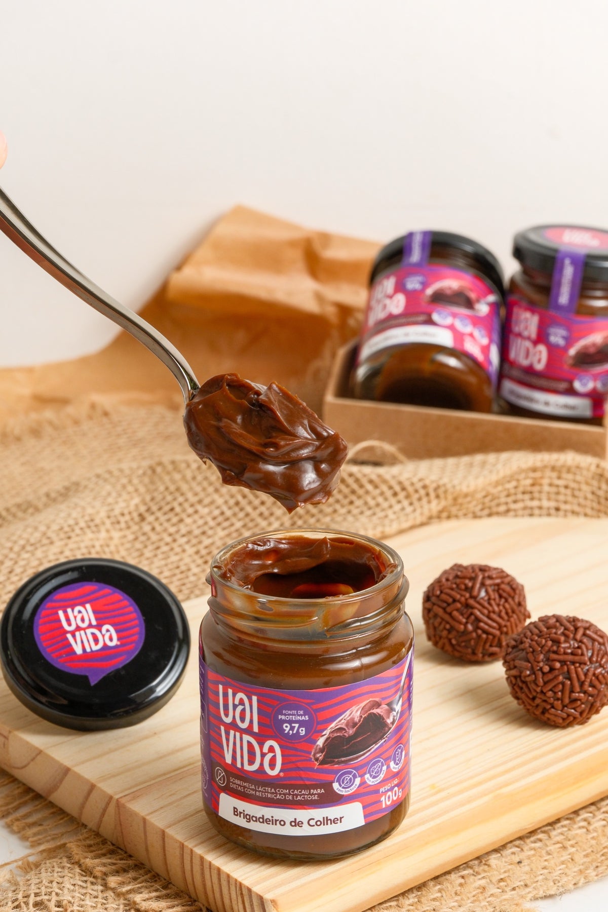 Brigadeiro de Colher Uai Vida — colher servindo porção cremosa sobre o pote aberto