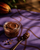Editorial brigadeiro — pote e colher dourada sobre tecido roxo com tracos, luz dramatica