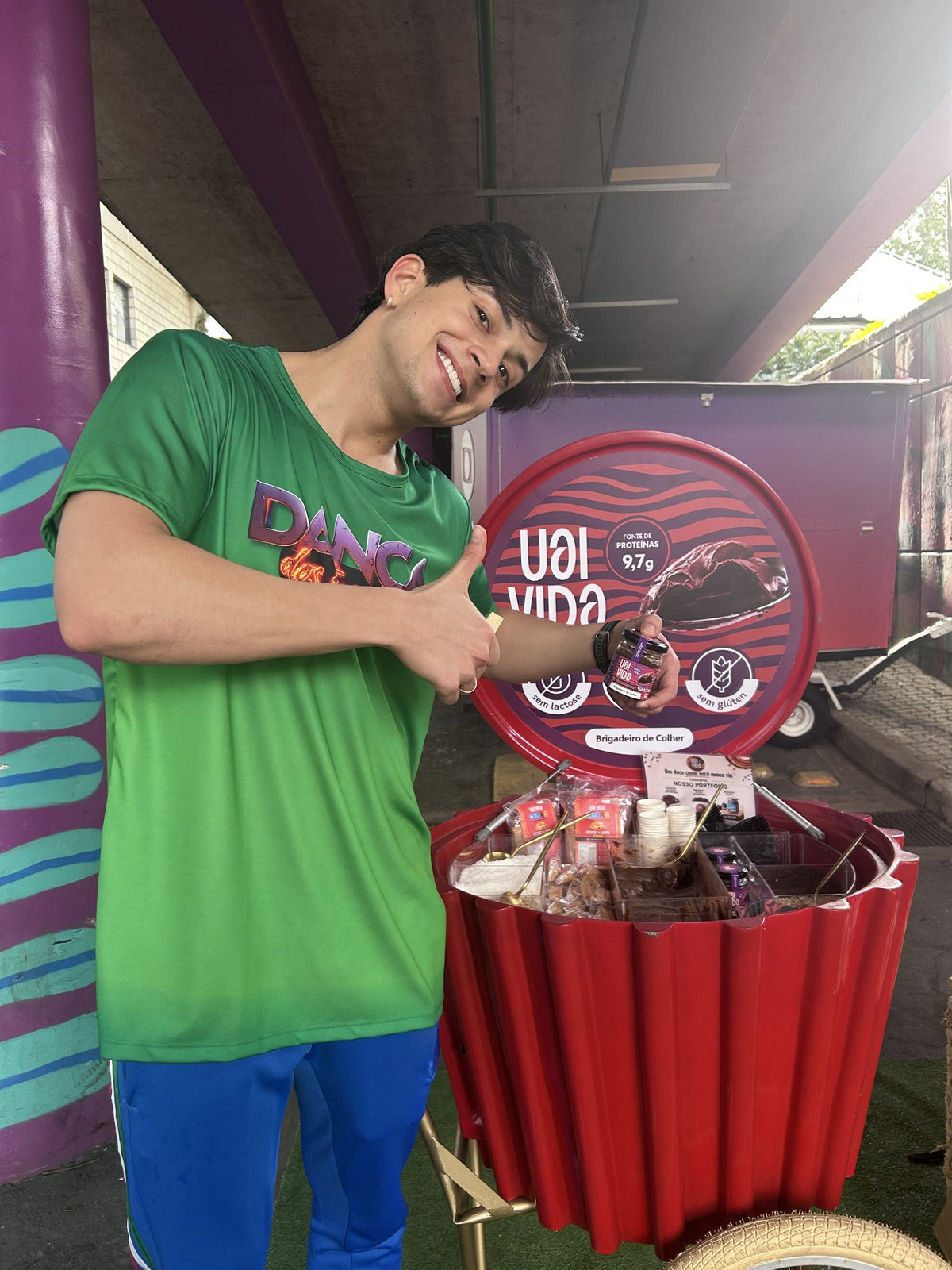 Leo Foguete segurando pote de Brigadeiro de Colher Uai Vida no carrinho de degustação da marca
