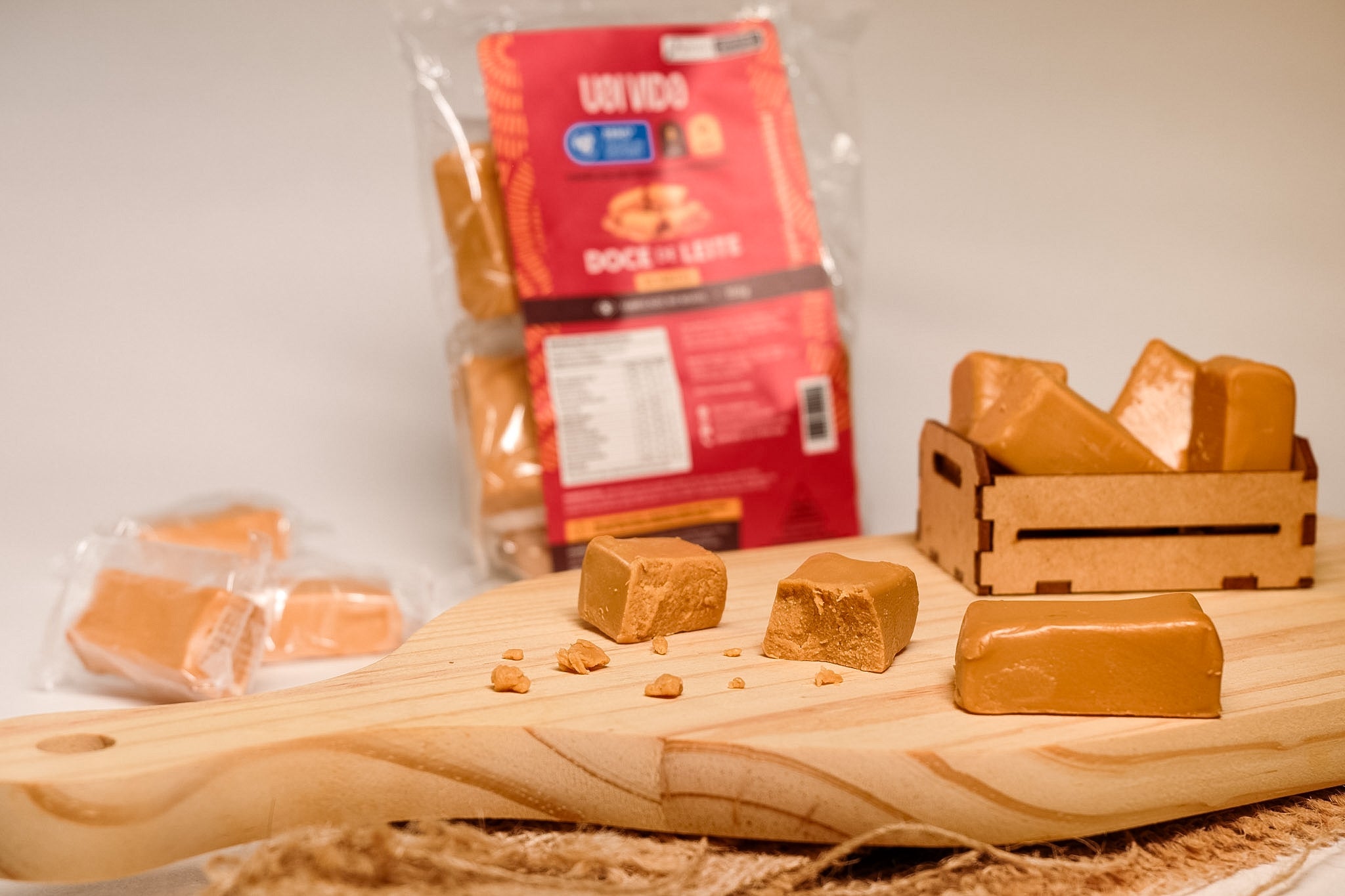 Doce de leite Uai Vida — cubo cortado em primeiro plano e tablete inteiro na tabua de pinus