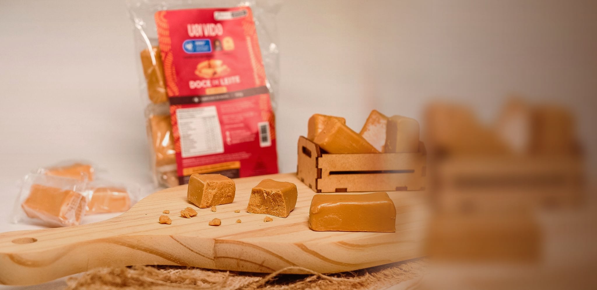 Doce de leite Uai Vida — pacote, caixinha, tabua de pinus e cubos cortados para hero desktop