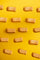 Doce de leite Uai Vida — pattern grid de tablets cubo coral espalhados sobre fundo amarelo pop